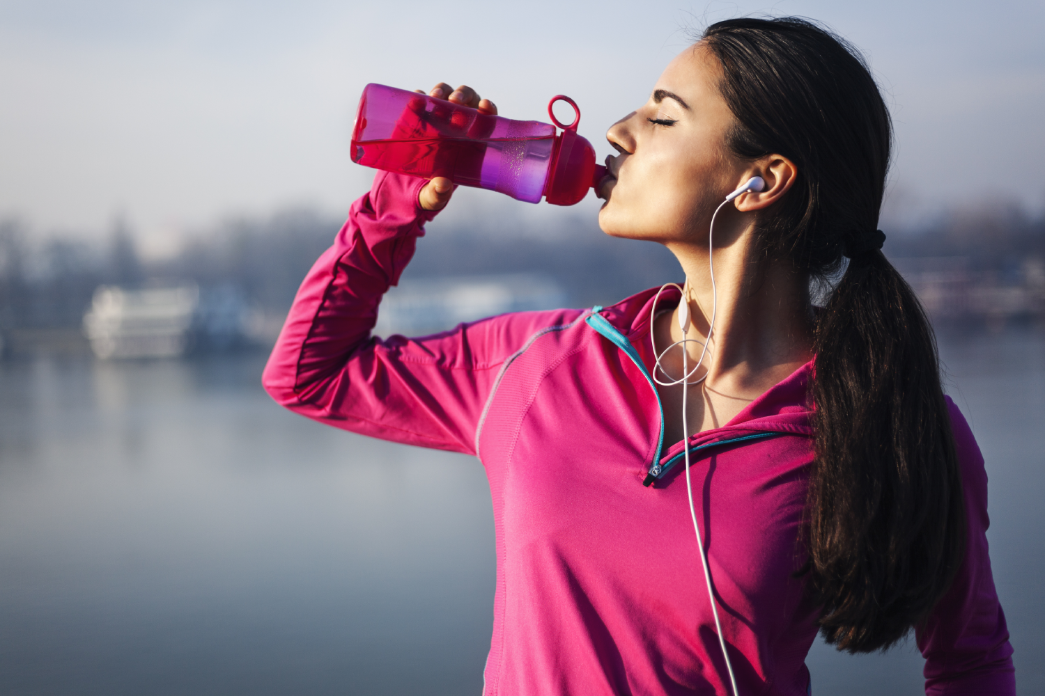 Woman drinking water after exercising for health benefits