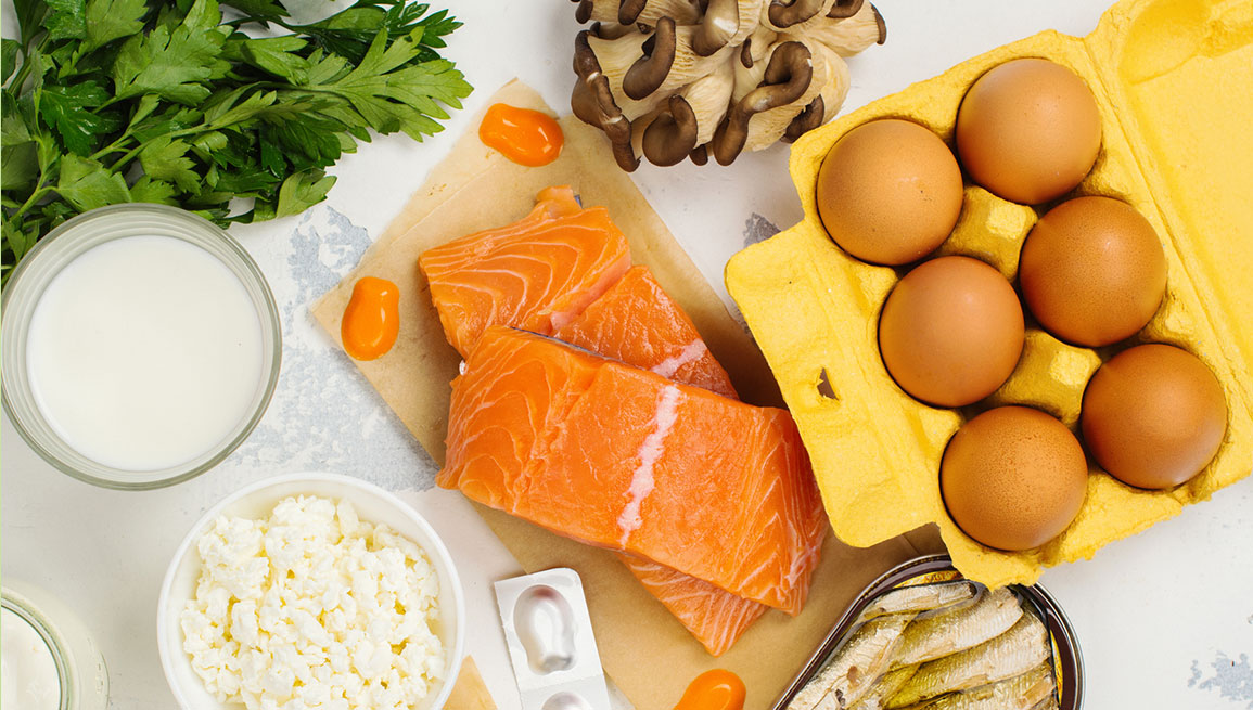 overhead view white tabletop background vitamin D foods raw salmon mushrooms eggs canned fish sardines green parsley vitamin D foods and supplement benefits vitafusion experience blog